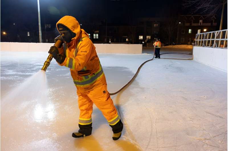 A worker sprays water at the Hibernia Square ice rink in Montreal to thicken fresh ice