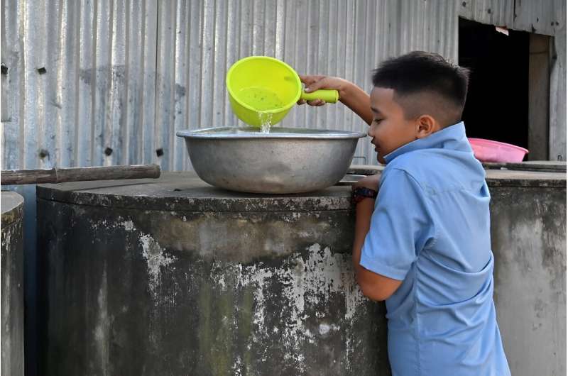 Un niño recoge agua dulce de un tanque en la provincia de Ben Tre, donde ahora algunos se ven obligados a comprar agua incluso para las necesidades domésticas.