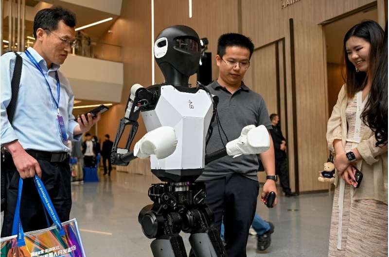 在上海举行的 2024 年中国人形机器人开发者大会上，双足机器人在会场上走来走去