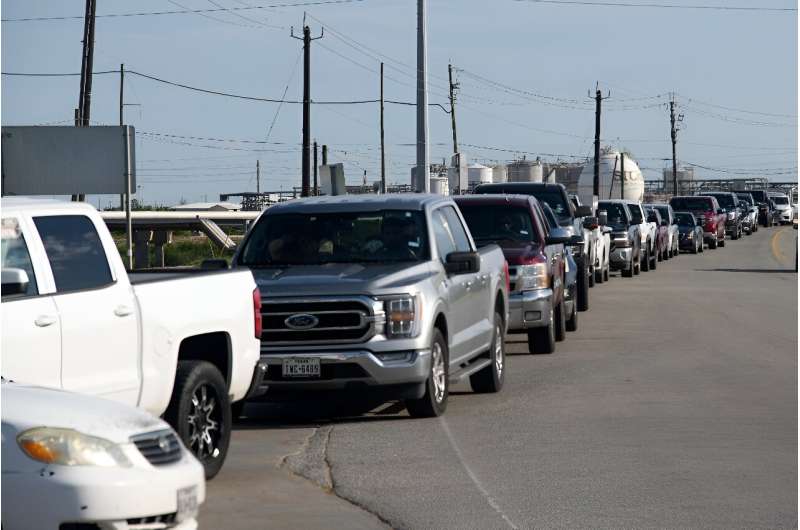 Cars line up outside a gas station after the passage of Beryl in Freeport, Texas