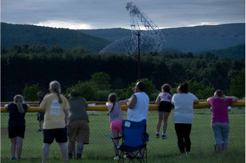 Children play softball in their school's field near the Green Bank Telescope, a 100-meter fully steerable radio telescope