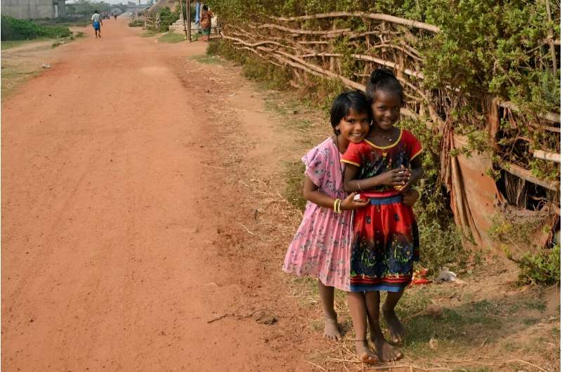 Children pose for a picture at a resettlement colony for people from the coastal village of Satabhaya