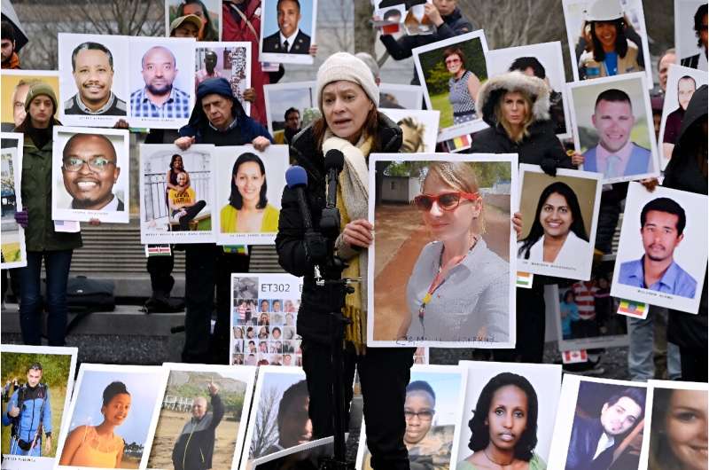 Families of victims of the March 10, 2019, crash of a Boeing 737 MAX airplane in Ethiopia hold up photos of the dead during a protest in Arlington, Virginia