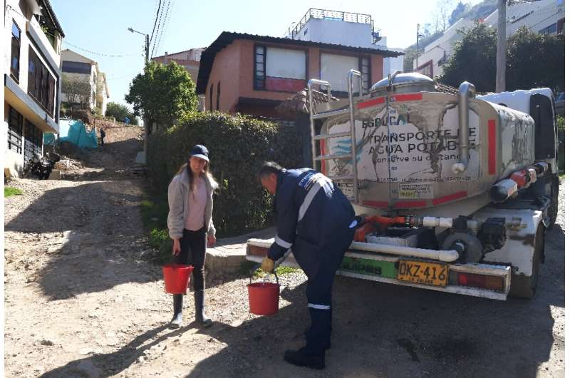 Graphic designer Clara Escobar collects drinking water from a water truck in La Calera, near Bogota
