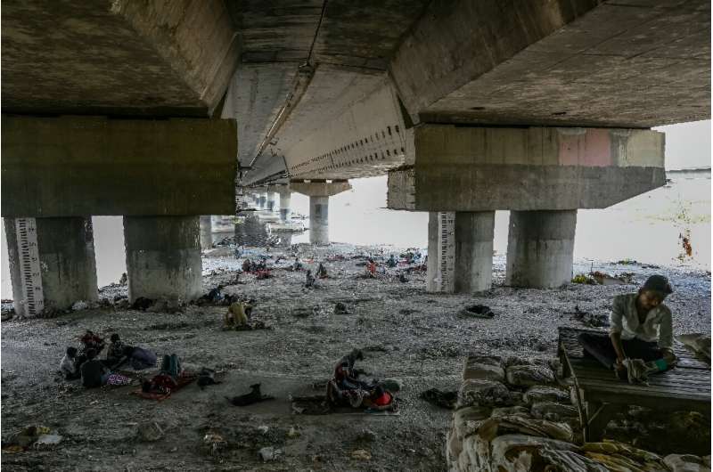 Homeless people are seen resting under a flyover to escape a searing heatwave in New Delhi on May 31