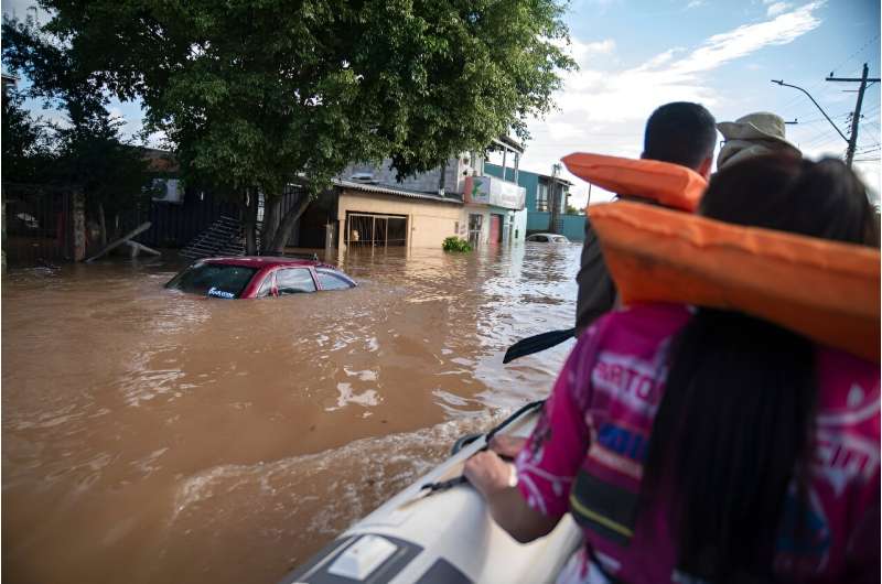 In the devastated town of Eldorado do Sul, boats pass through streets that have turned into rivers, bringing food to those who refuse to leave their homes