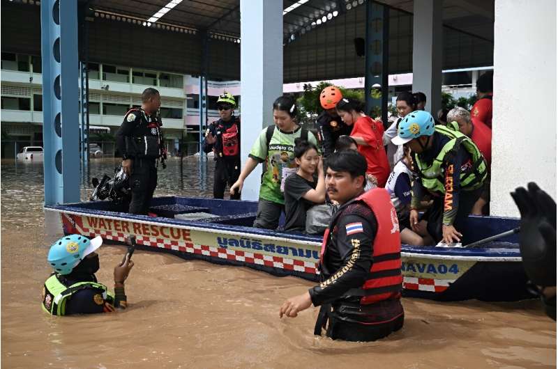 Local rescue teams pick up schoolchildren who were trapped overnight during flooding in the northern Thai city of Chiang Rai on September 12