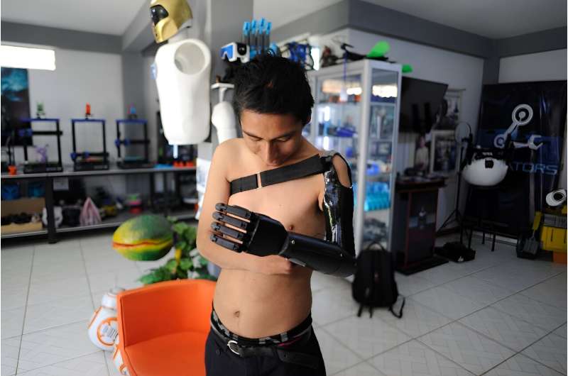 Marco Antonio Nina, 26, who lost his left arm at the age of 14 in a work accident, tests his bionic arm prosthesis that Roly Mamani made for him in his 'Robotics Creators' workshop in Achocalla, Bolivia, on January 8, 2024