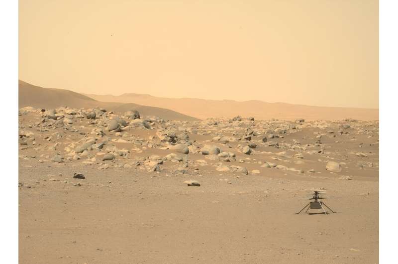 NASA's tiny Ingenuity helicopter is seen sitting on the surface of Mars in a photograph taken by the rover Perseverance