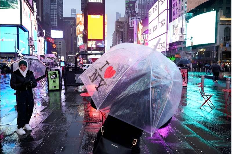 People carry umbrellas on Times Square in New York  as the northeastern US is hit by bad weather