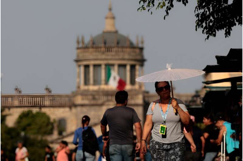 People protect themselves from the sun during a heat wave hitting the country, in Guadalajara, Jalisco state, Mexico, in May 2024