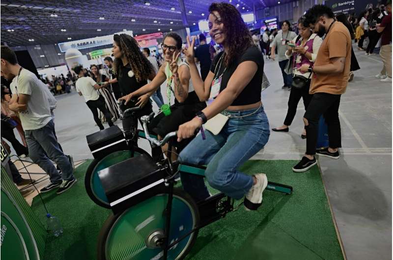 La gente anda en bicicletas estáticas para generar energía durante la Web Summit Rio 2024 el 17 de abril de 2024
