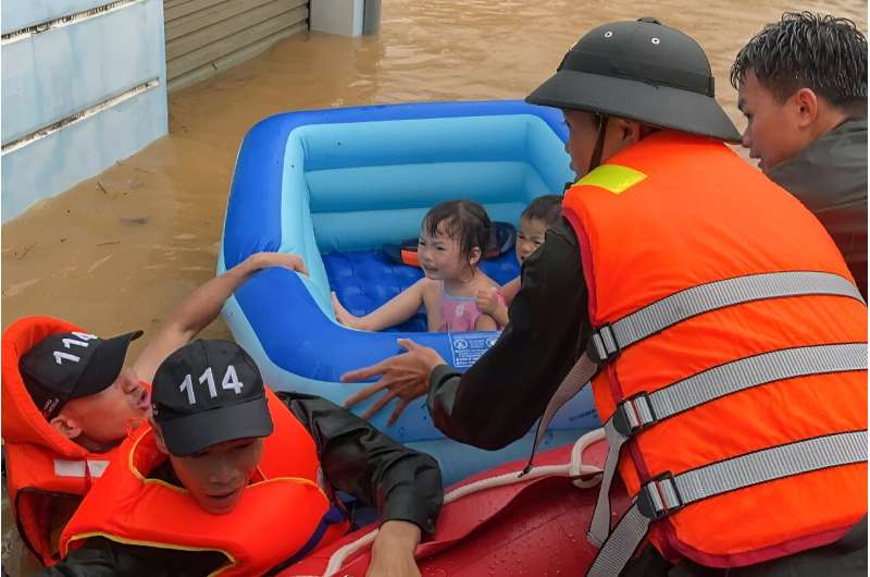 Rescuers help children escape flood waters in Vietnam's northern Ha Giang province on June 10