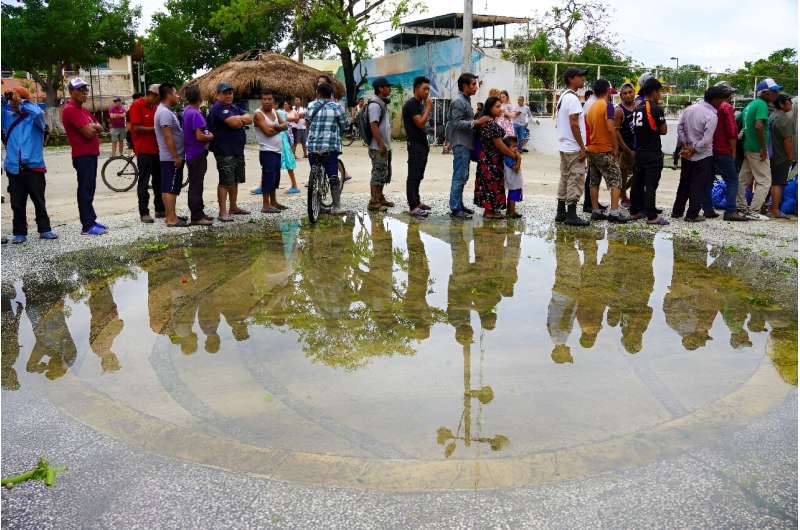 Residents in Tulum, Mexico, queue to receive food rations provided by the Mexican army following the passage of Hurricane Beryl