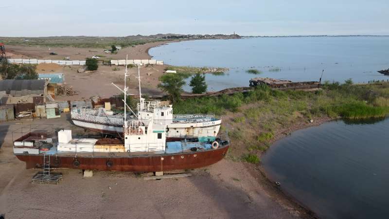 Rusting fishing boats beached on the edge of Kazakhstan's Lake Balkhash