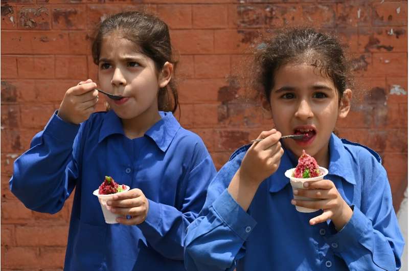 Students eat ice cream outside their school in Lahore, the capital city of Pakistan's Punjab province, where schools will close a week early because of extreme temperatures