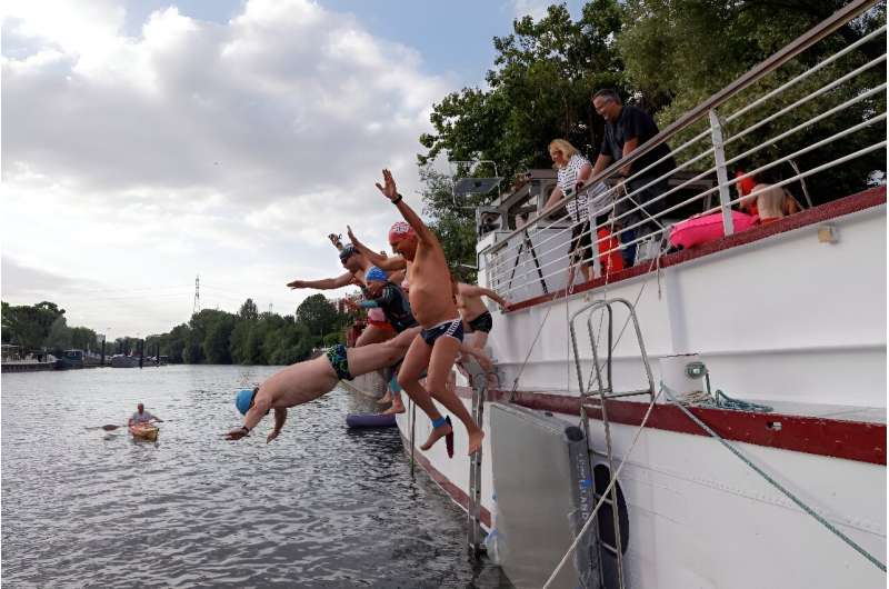 Swimmers plunge into the Seine near the Olympic Village on the Ile Saint Denis just outside Paris