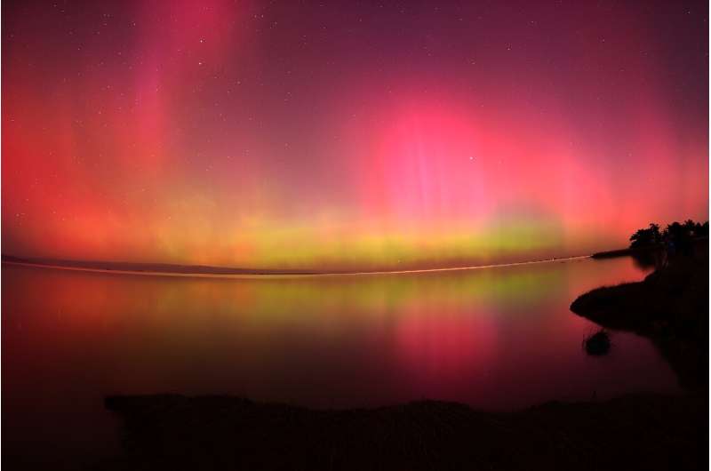 The Aurora Australis, also known as the Southern Lights, glows over Lake Ellesmere outside Christchurch in New Zealand after the most powerful solar storm in more than two decades