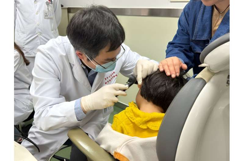 This handout picture courtesy of the Eye &amp; Ent Hospital of Fudan University shows Dr Yilai Shu examining a young patient at the Eye &amp; ENT Hospital of Fudan University in this image taken on April 17, 2024