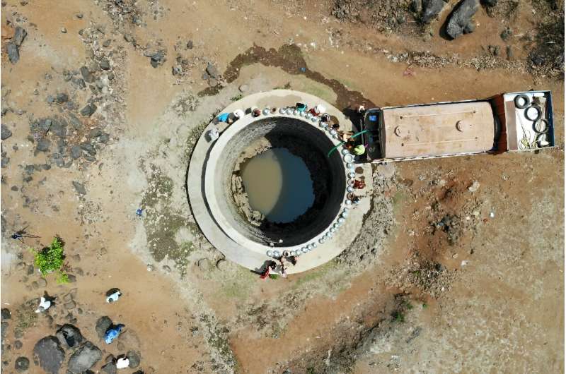 Villagers wait at a well to fill water, in Shahapur district of India's Maharashtra state