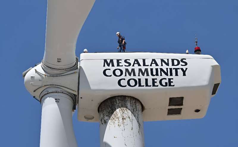 Wind turbine technician Terrill Stowe stands on the nacelle, which houses the gearbox and generator, atop the tower of a wind turbine on the campus of Mesalands Community College in the former Route 66 town of Tucumcari, New Mexico