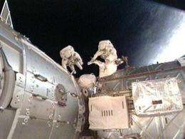 Astronauts work outside the International Space Station