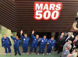 Members of the Mars500 crew wave before being locked into the isolation facility in Moscow,