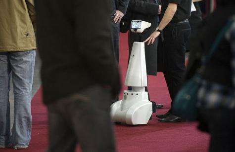 Visitors walk past the robot "Jazz" by French company Gostai