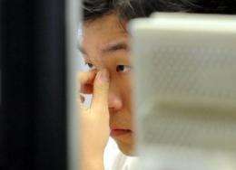 A South Korean dealer checks a computer screen inside the dealing hall at the Korean Exchange Bank in Seoul
