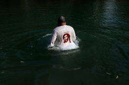 A Christian pilgrim walks in the waters of the Jordan River in 2009