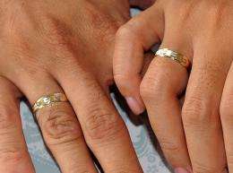 A couple holds hands showing their wedding rings