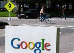 A cyclist rides by a sign outside of the Google headquarters in Mountain View, California