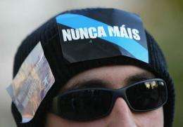 A demonstrator shows a "Nunca mais" (never again) sticker in his head during a demonstration