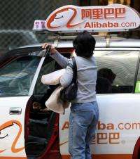 A Hong Kong taxi is seen adourned with the logo of e-commerce firm Alibaba.com