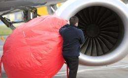 Airport staff secure dust covers on the engines of a passenger aircraft at Belfast City Airport