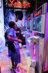 A man plays the video game Yakuza by Sega while talking on his cell phone in Los Angeles