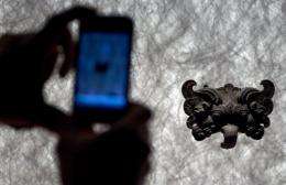 A man takes a photo with a mobile phone at an exhibition in Santiago, Chile