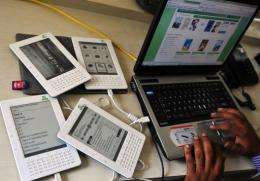 A man works on his laptop as he uploads e-books and synchronises with the attached Kindle-style tablet called Wink