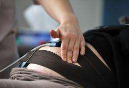 A midwife examines a pregnant woman