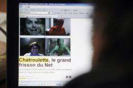 A person watches a web page displaying webcam pictures from the Chatroullette website