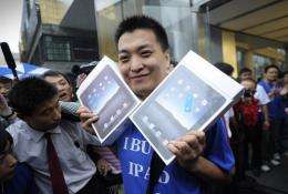 Apple customer Han Ziwen holds up his ipads
