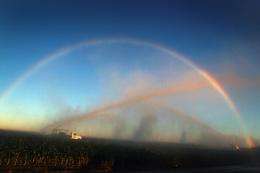 A rainbow is formed as irrigation trucks spray water over plants in an effort to keep them from freezing in Florida