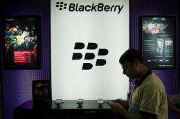 A salesman stands next to a BlackBerry display in a shop