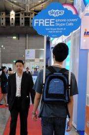 A Skype promoter walks with a sign at the CommunicAsia 2010 conference