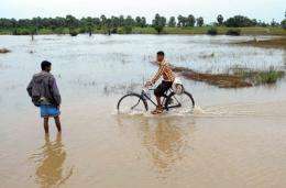A Sri Lankan man rides his bicycle through a flooded road of the eastern district of Batticaloa's Kiran area