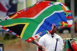 A street vendor selling flags waves a South African national flag decorated with those of the countries participating