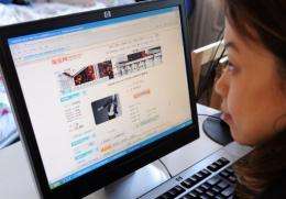 A woman shops online in Beijing as online sales in China rose 22 percent in 2010