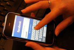 A woman types her password to enter Facebook via her phone