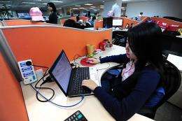 A woman works online in her cubicle at an office in Beijing