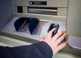 A worker of Polish Bank BPS shows how to withdraw money from a new cash machine